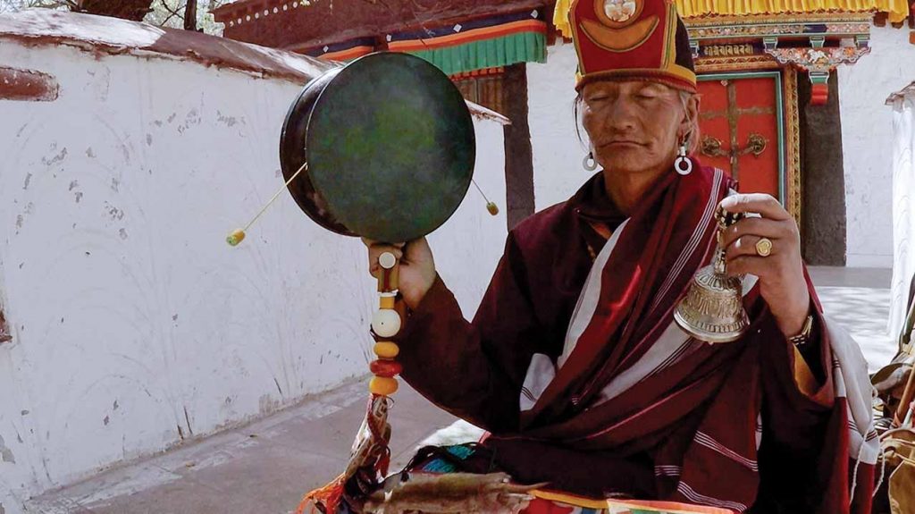 Monk drumming at Lukhang temple. Photo © David Bickerstaff