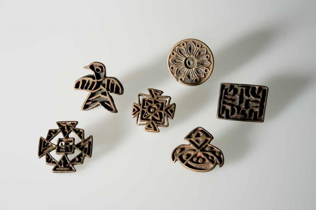 Some examples of the different stylistic categories of Nestorian crosses displayed in the exhibition, including a bird-shaped cross, a Greek cross with a swastika in the centre and a circular cross with a floral motif