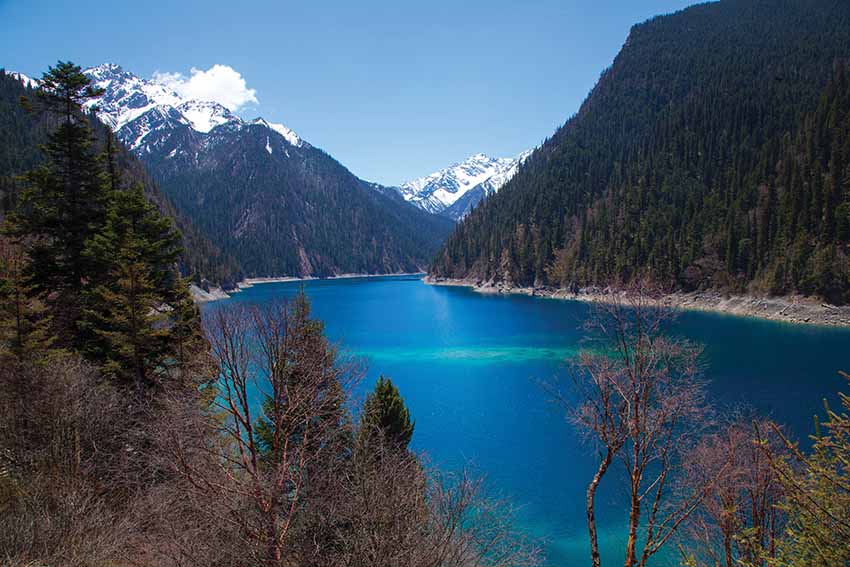 Chengdu Art Trail: Long Lake is crescent-shaped and is the highest (3,000 m), largest and deepest lake in Jiuzhaigou, measuring 7.5 km in length and up to 103 m in depth. It reportedly has no outgoing waterways, getting its water from snowmelt and losing it from seepage. Local Tibetans call the lake “a magic gourd that will never be poured full or dried up”.